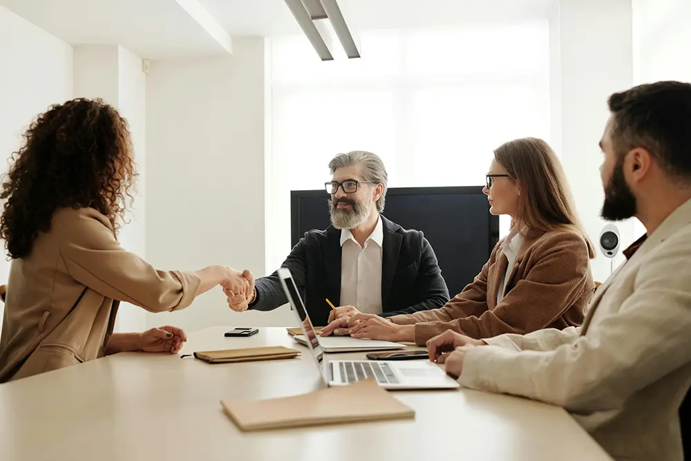 Professionals meeting and shaking hands in a collaborative workforce consultation
