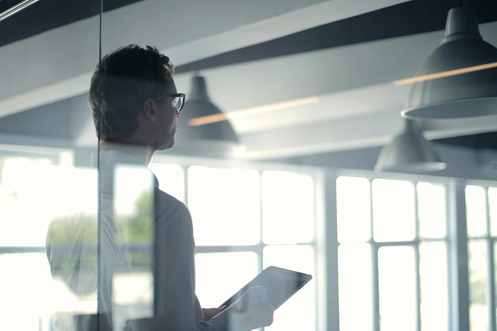 A business professional reviewing a tablet in an office